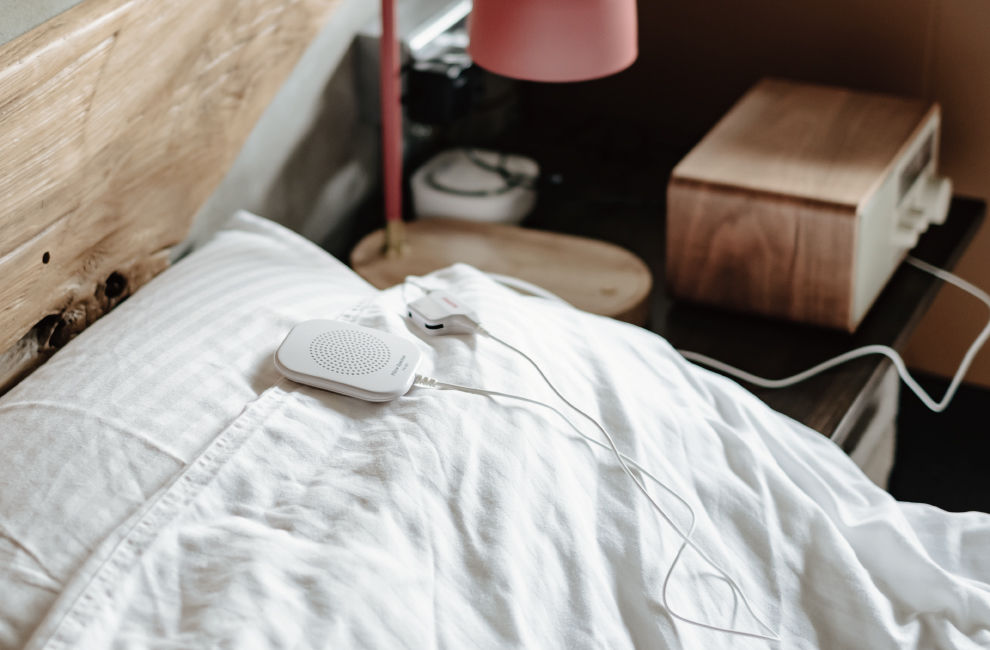 a SANGEAN pillow speaker is on the bed